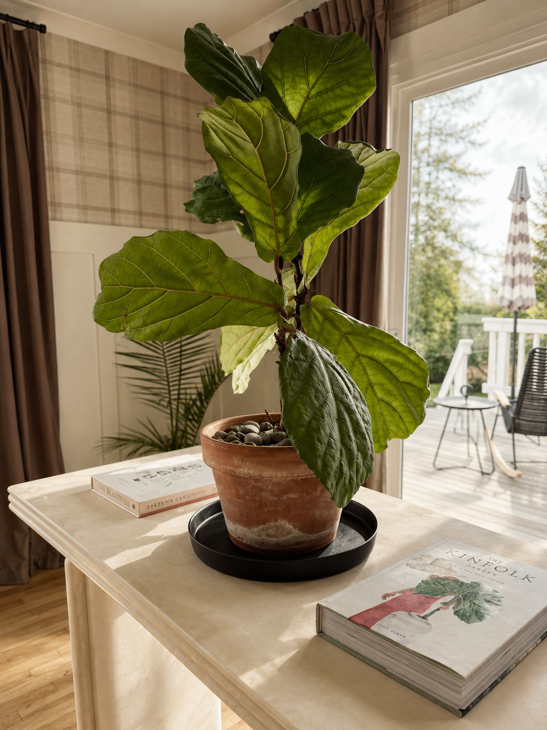 Beck Road breakfast nook — travertine round pedestal table, olive velvet curved chairs, Pacific Northwest garden view