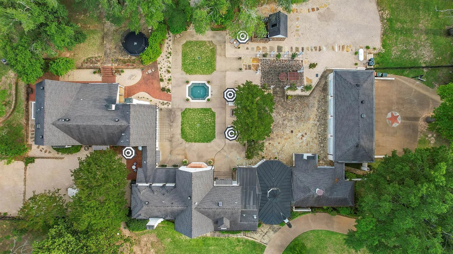 Tyler Estate aerial — multiple structures, pool, stone courtyards, mature trees across the full estate compound