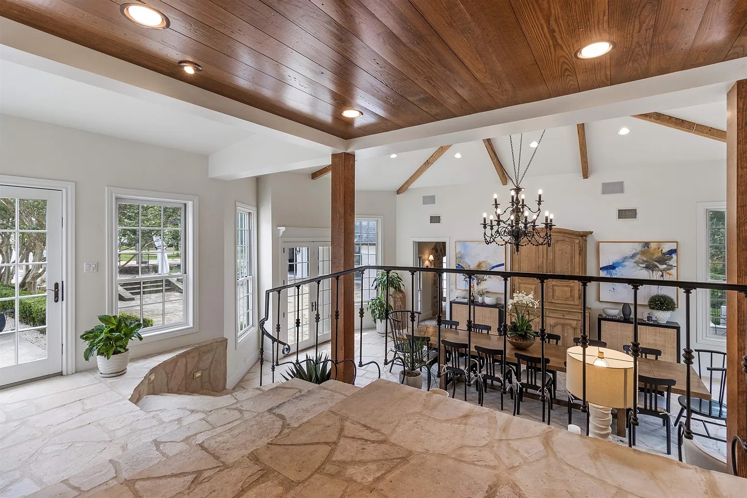 Tyler Estate landing — cedar ceiling with wrapped timber columns, wrought iron railing, stone steps, view down to dining room